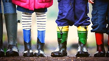 Lasten jalkoja erilaisissa kengissä.